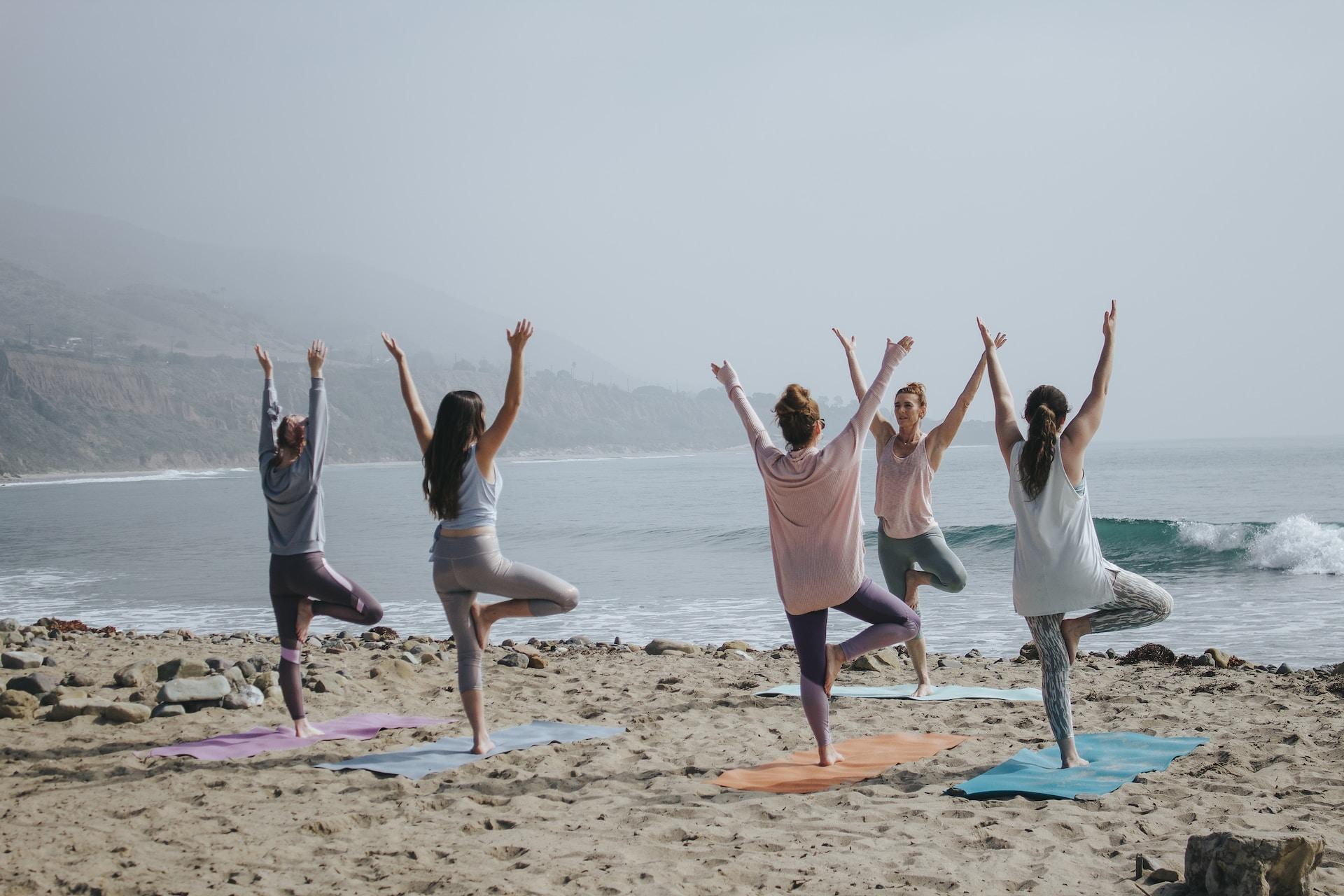 Un grupo de personas practicando yoga en la playa