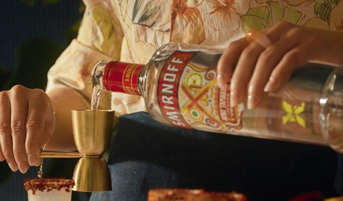 Woman pouring a bottle of Smirnoff Spicy Tamarind into a jigger