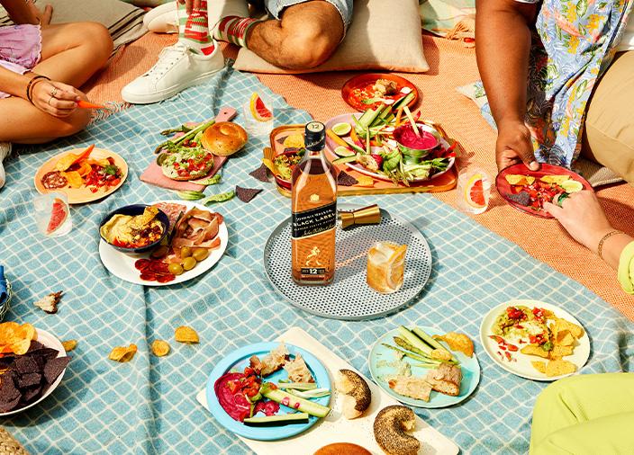 Bottle of Johnnie Walker Black Label on a table surrounded by food