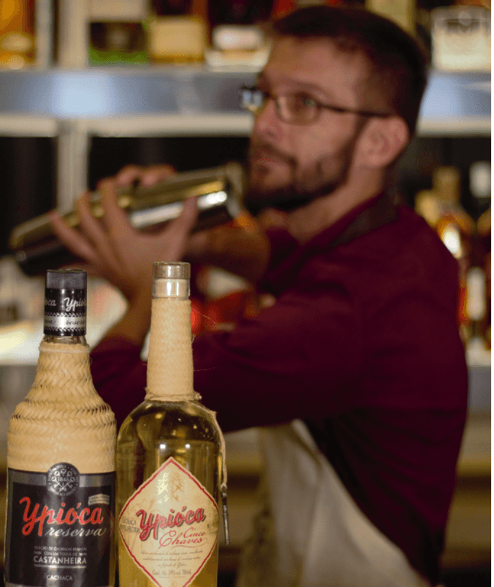Imagem de um bartender batendo um coquetel com cachaça 
