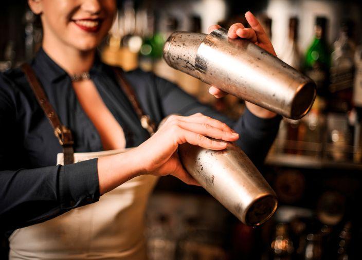 Bartender using two cocktail shakers.