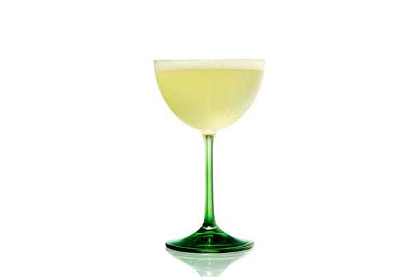 Cocktail in long green stemmed coupe glass