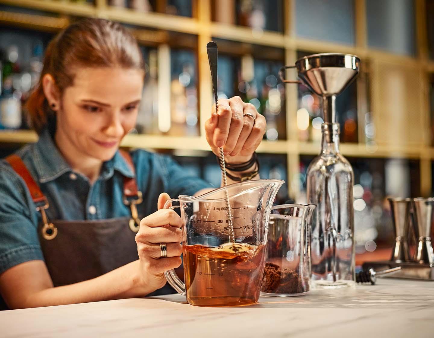 Drink questions quiz - Bartender focusing on measuring drink 