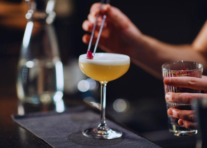 Bartender garnishing a premium cocktail.