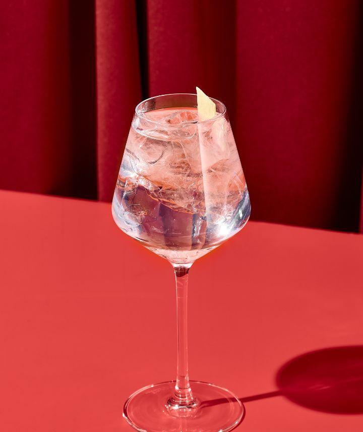 Ein Cocktail steht auf einem roten Untergrund