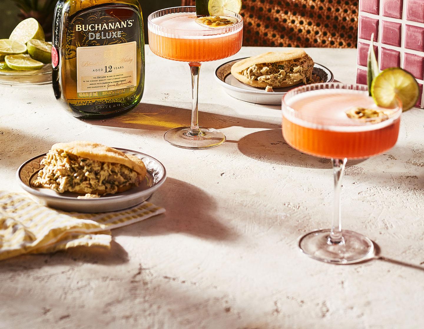 2 cocktails with plates of food