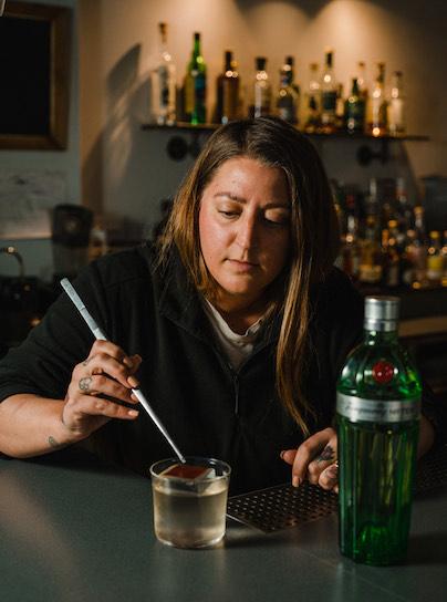 Katie Rouse garnishing a gin cocktail
