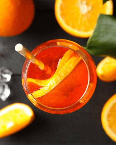 copa de coctel spritz con cubos de hielo y decorado con limon, romero
