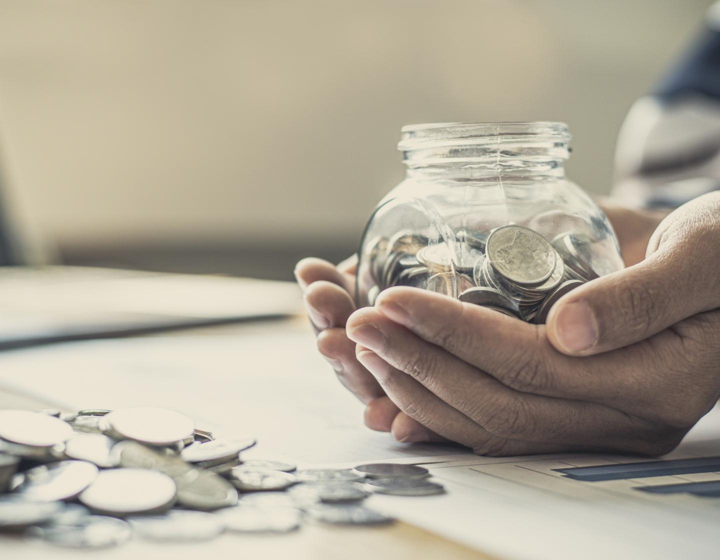 Person holding jar of coins