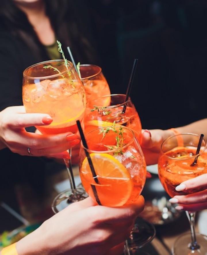 Orangene Spritz-Cocktails werden angestoßen