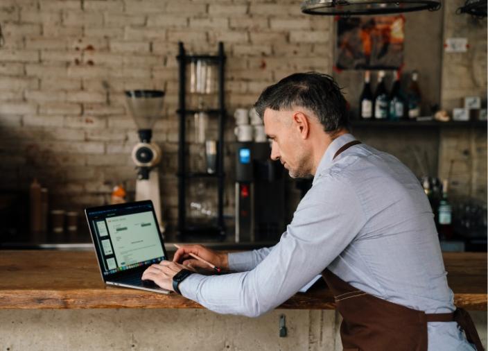 BAR MANAGER WORKING AT LAPTOP