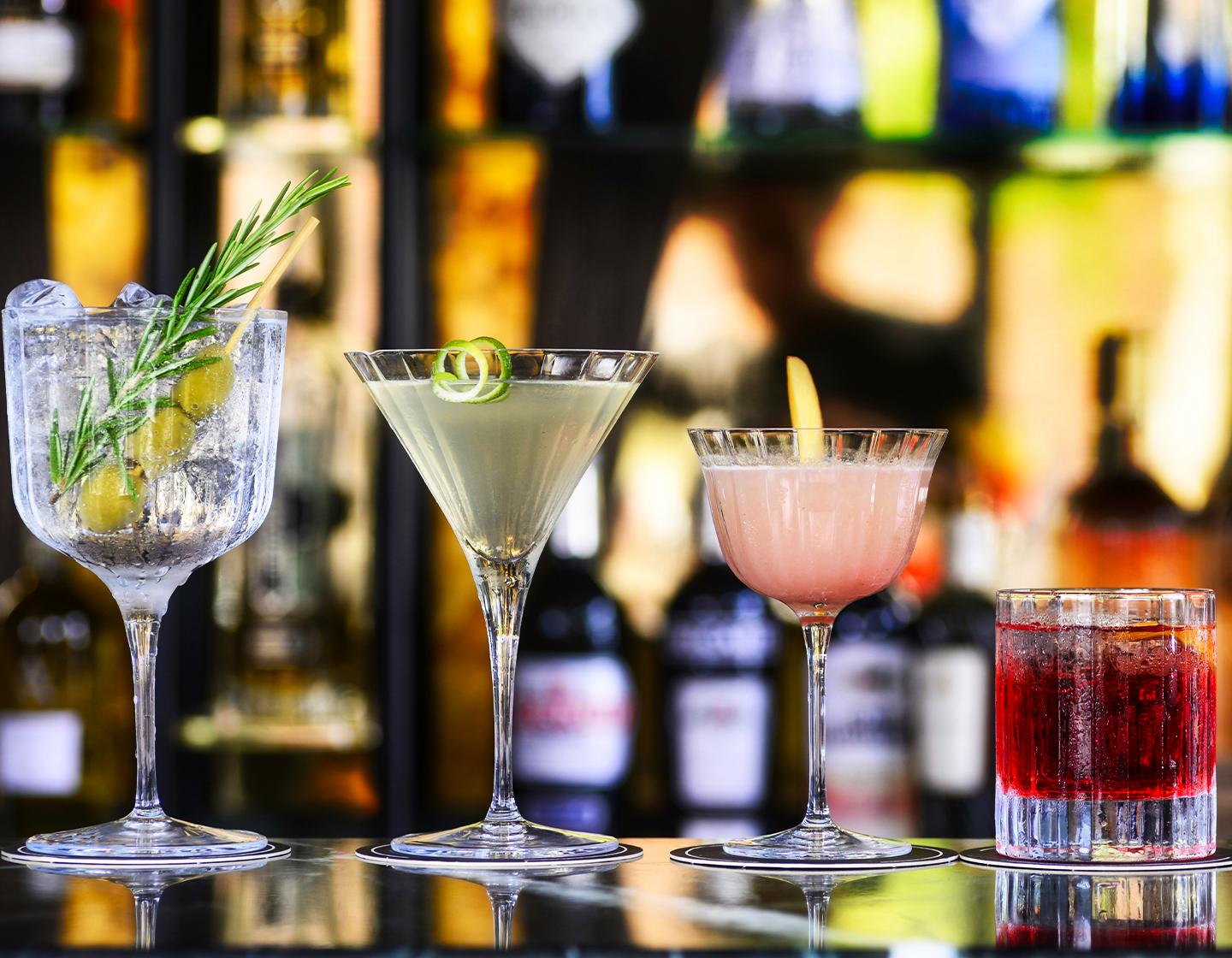 Four cocktails presented on bar header