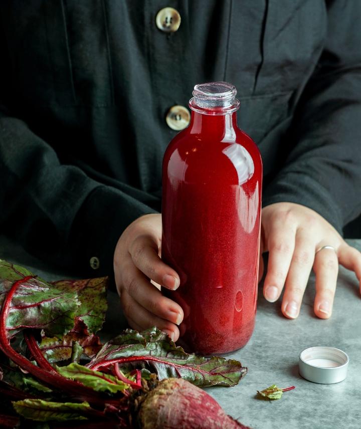 Beetroot juice in glass bottle on worktop