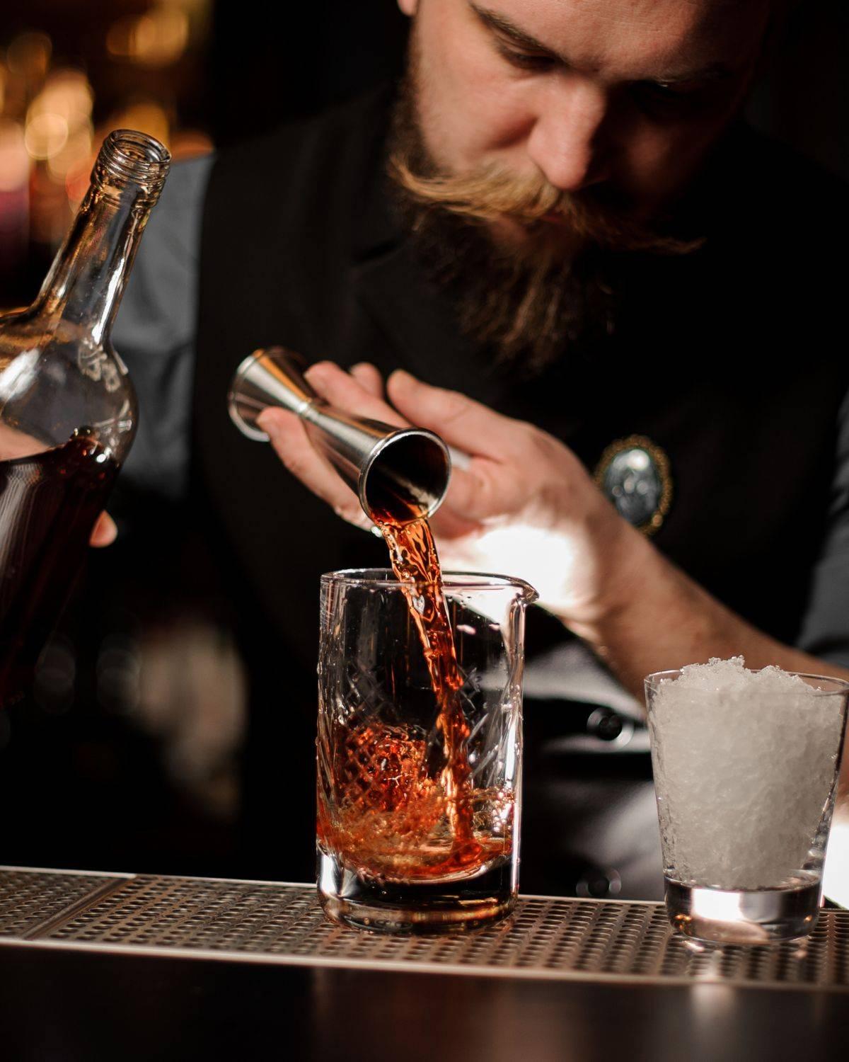Bartender sirviendo una medida precisa de whisky