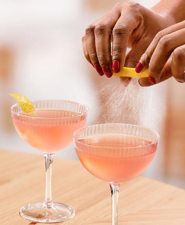 Cóctel en una mesa junto con naranjas y una botella de KetelOne