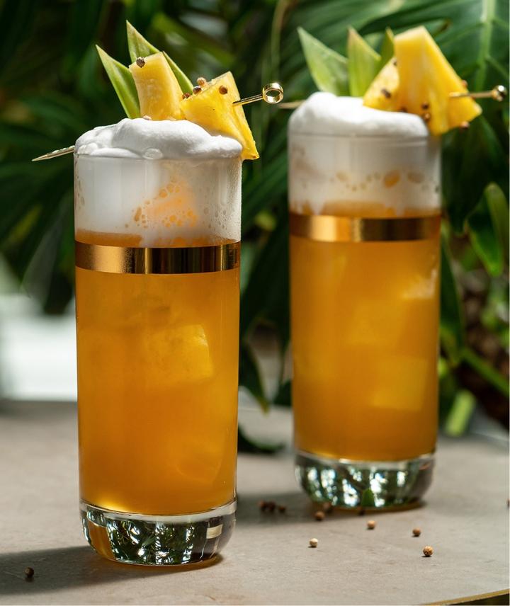 Two air cocktails with cloud foam top with pineapple garnish