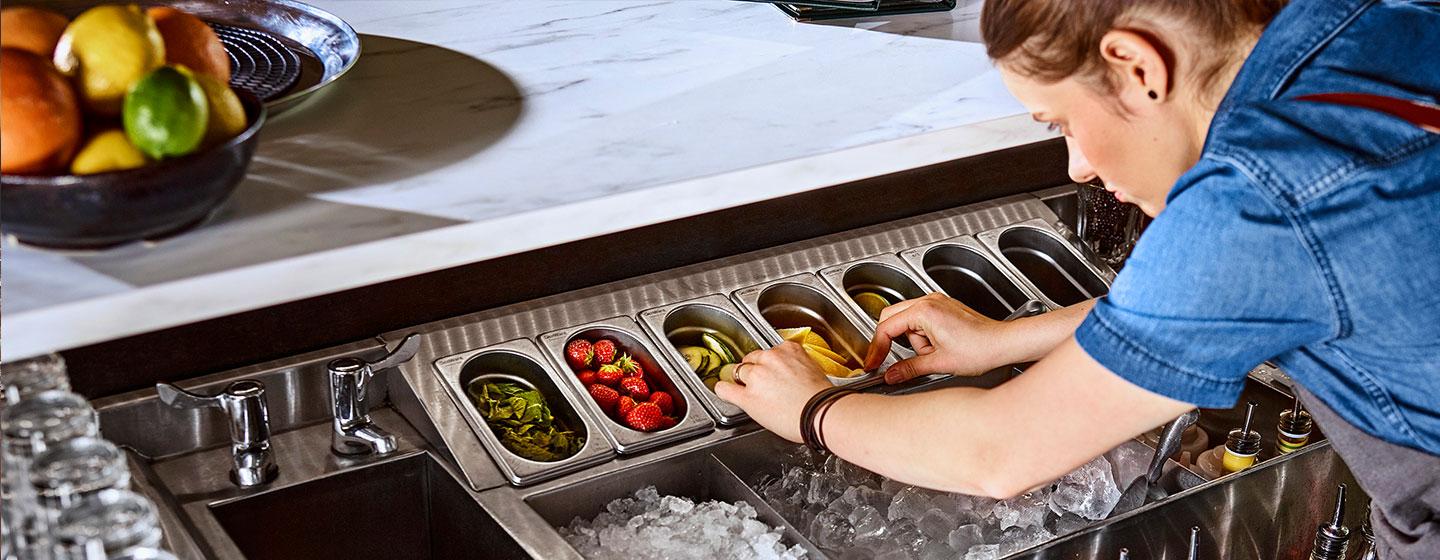 Bartender setting up garnish