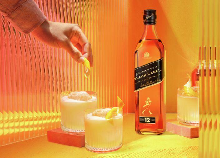 Whisky in a glass on ice with an orange rind inside it.