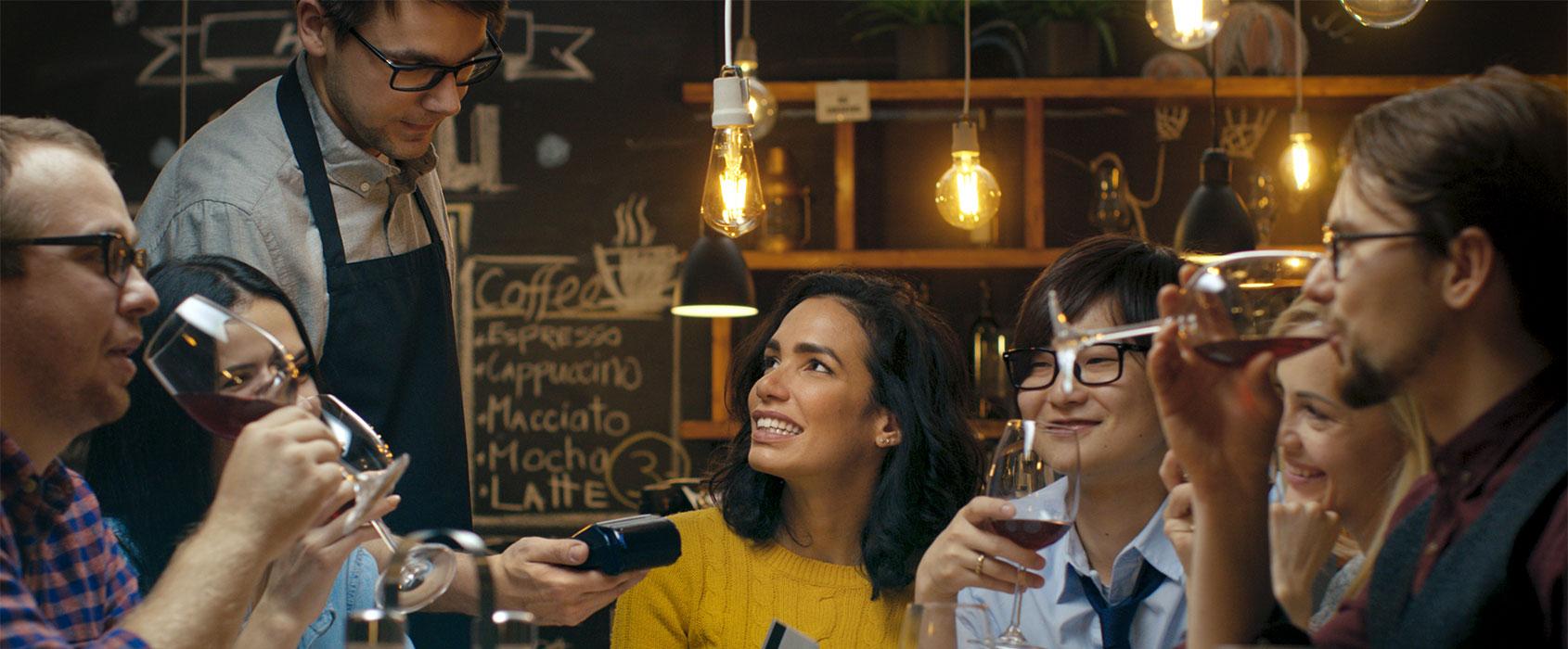 Camarero entregando máquina de tarjetas a cliente