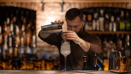 Bartender sirviendo un trago cuidadosamente