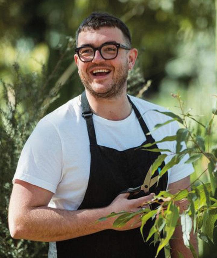 Evan picking some fresh herbs to garnish a cocktail