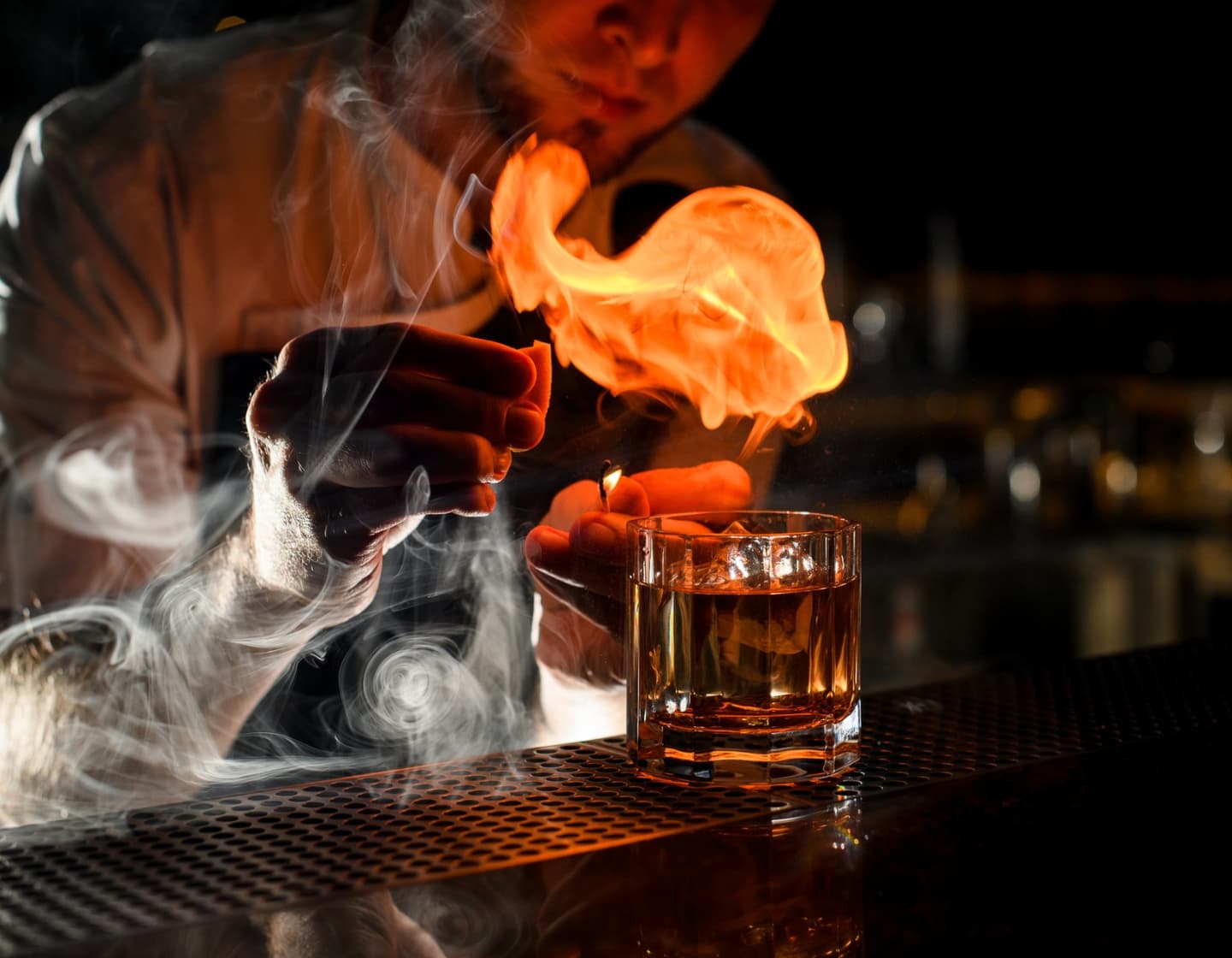 Un bartender sirviendo un cóctel con fuego