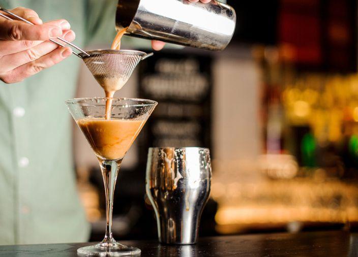 Cóctel de café vertido en un vaso por un bartender.