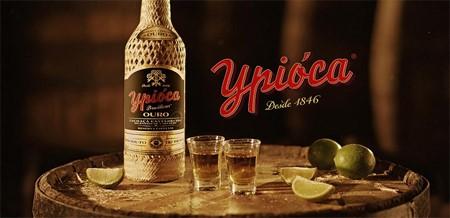 Imagem promocional da garrafa de Ypióca com copos e limões 