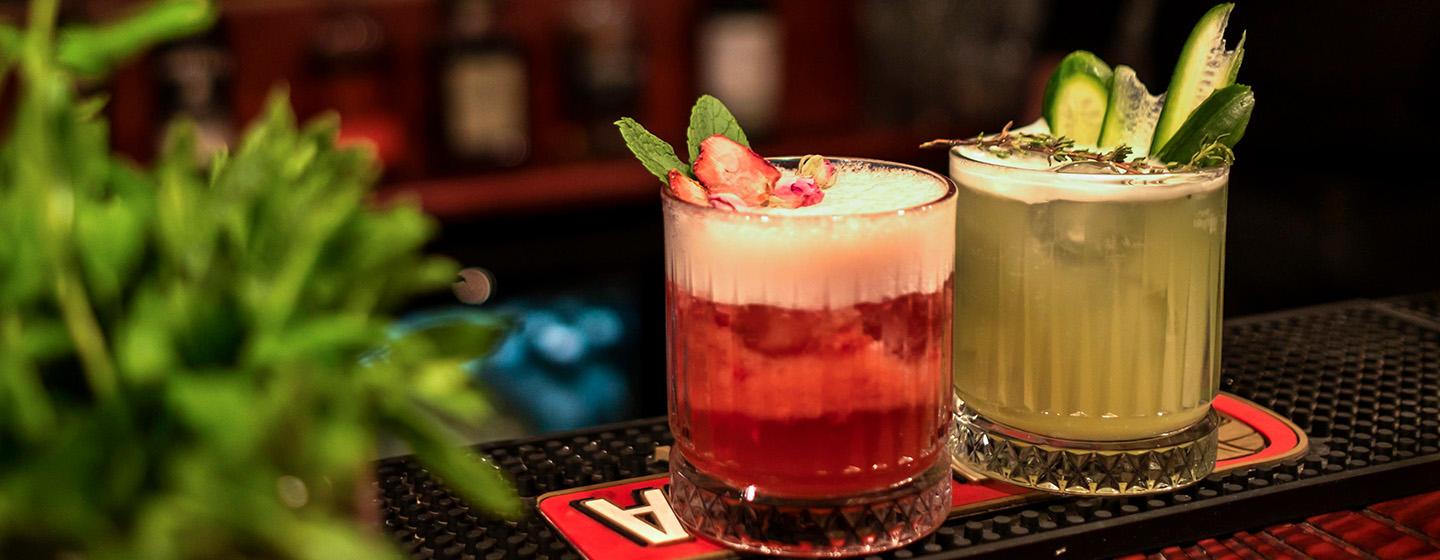 Two cocktails with foam and garnish