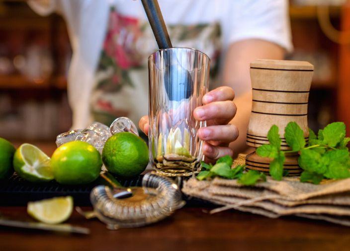Limas y hojas de menta se mezclan para preparar un cóctel.