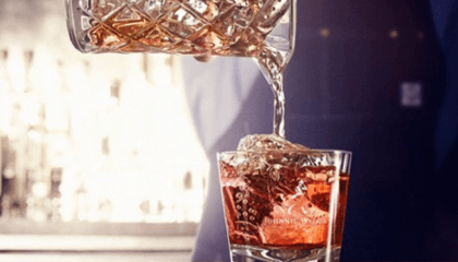 bartender sirviendo licor en vaso con hielo