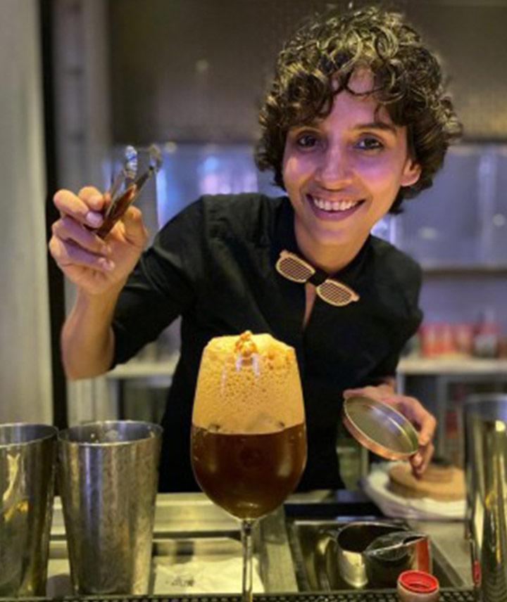 Ami Shroff mit einem dunklen Drink, dem Namaste Honey