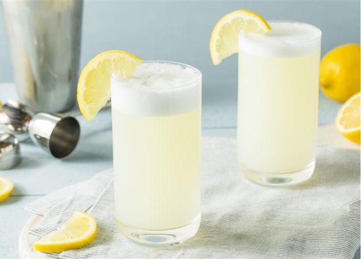 Dos cócteles con tapa de espuma y guarnición de limón.