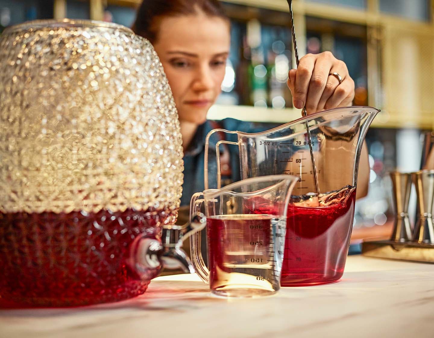 bartender stirring mixture for a batched cocktail