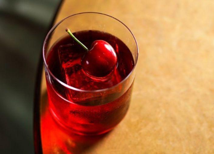 A negroni cocktail with a cherry garnish.