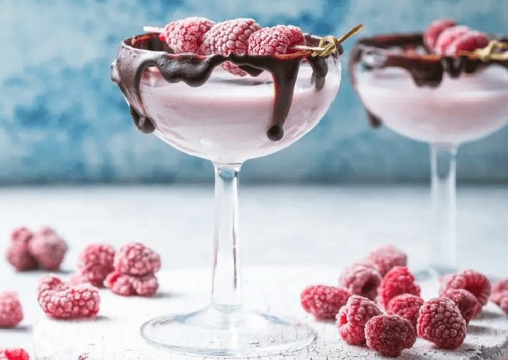 Dos cócteles de san valentín decorados con chocolate y frambuesas