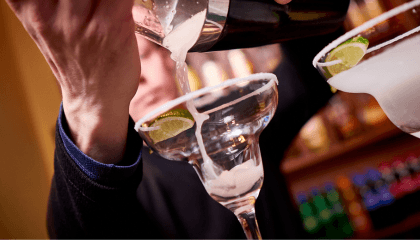 Bartender sirviendo un trago en una copas