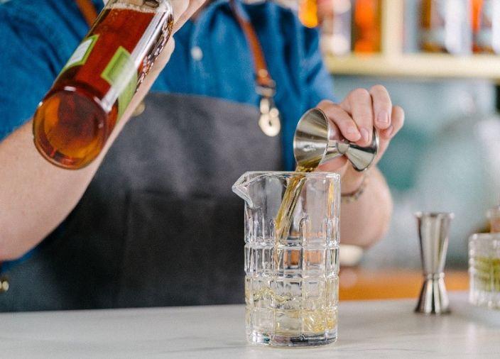 Liquid being poured from a jigger to a glass   