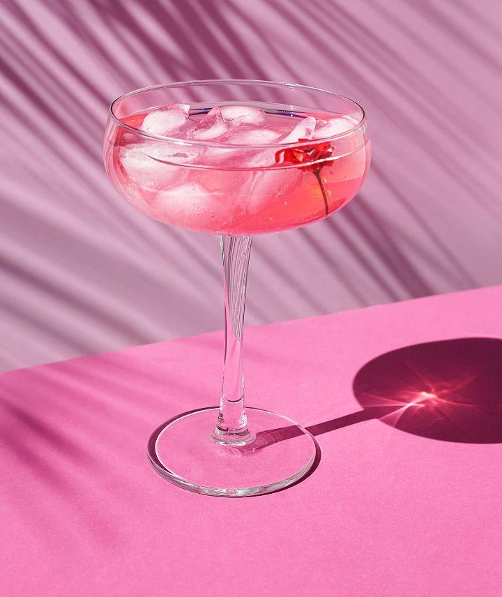 Ein pinker Cocktail auf einem pinken Untergrund