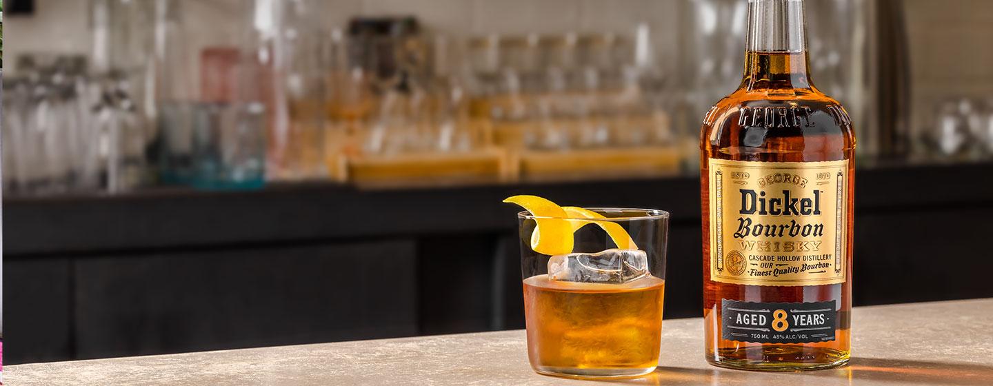 Bottle of Dickel on table with cocktail