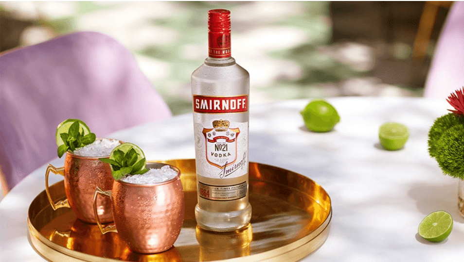 Smirnoff No.21 Premium Vodka on a tray with vodka cocktails in copper mugs
