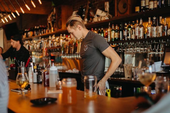 Bartender steht hinter der Bar