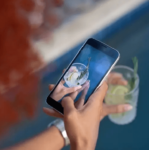 persona tomando una foto a su cóctel 