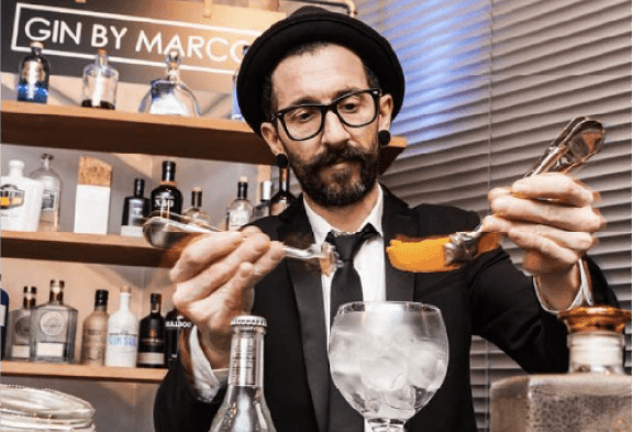 Bartender adornando un cóctel con una piel de naranja
