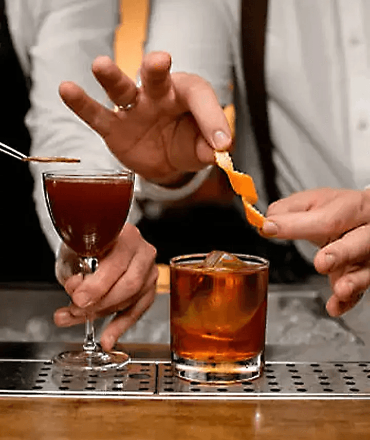 Imagen de los cócteles con una persona poniendo el garnish 