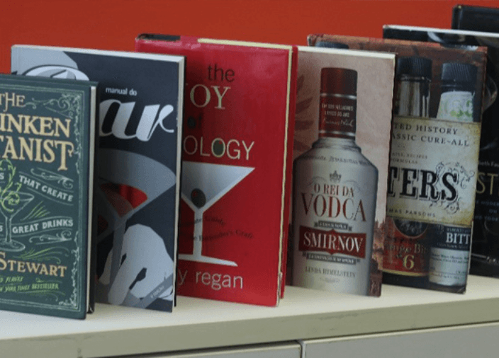 Imagem de uma biblioteca com livros sobre Bartending 