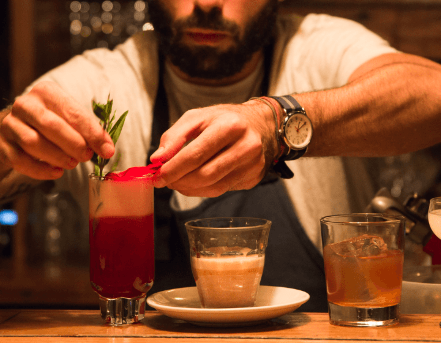 Bartender placing garnishes on a variety of cocktails 