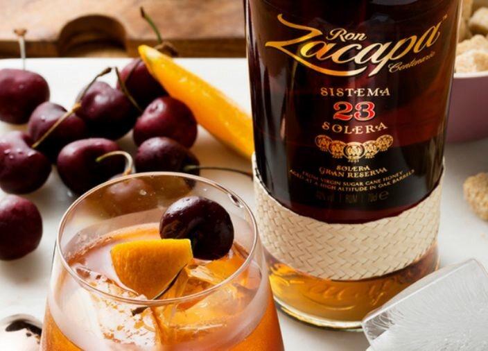 Zacapa Rum next to a glass of rum and fruit.
