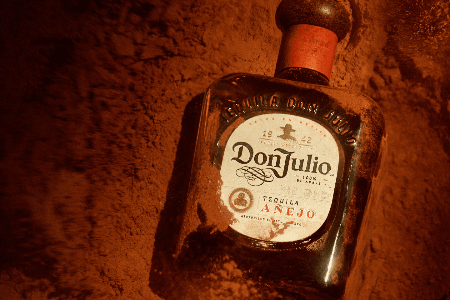Garrafa de tequila Don Julio Añejo em frente a uma porta vermelha 