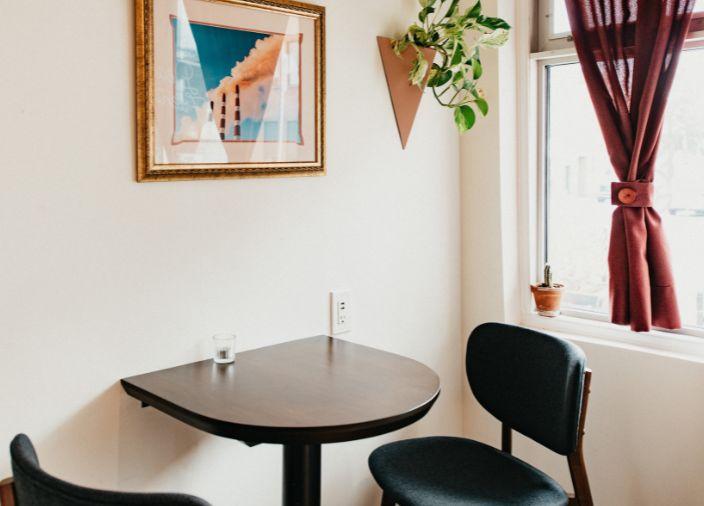 Pequeña mesa de madera y dos sillas en un ambiente de bar.